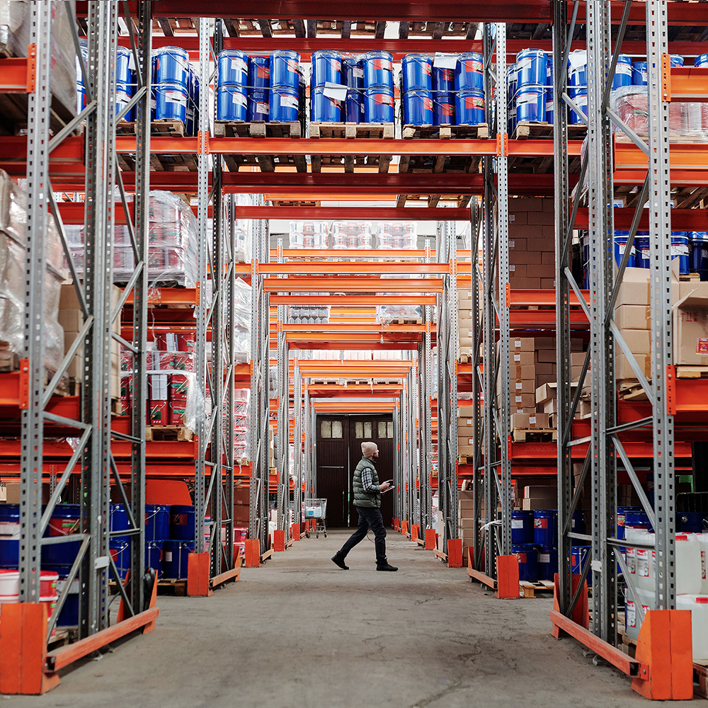 Large storage facility with high ceiling and all manners of drums, boxes, plastic cans etc.