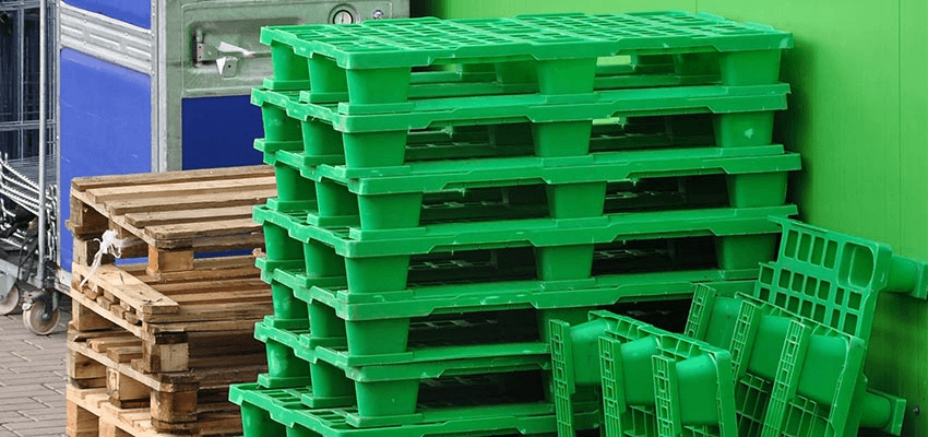 A large pile of green plastic pallets.