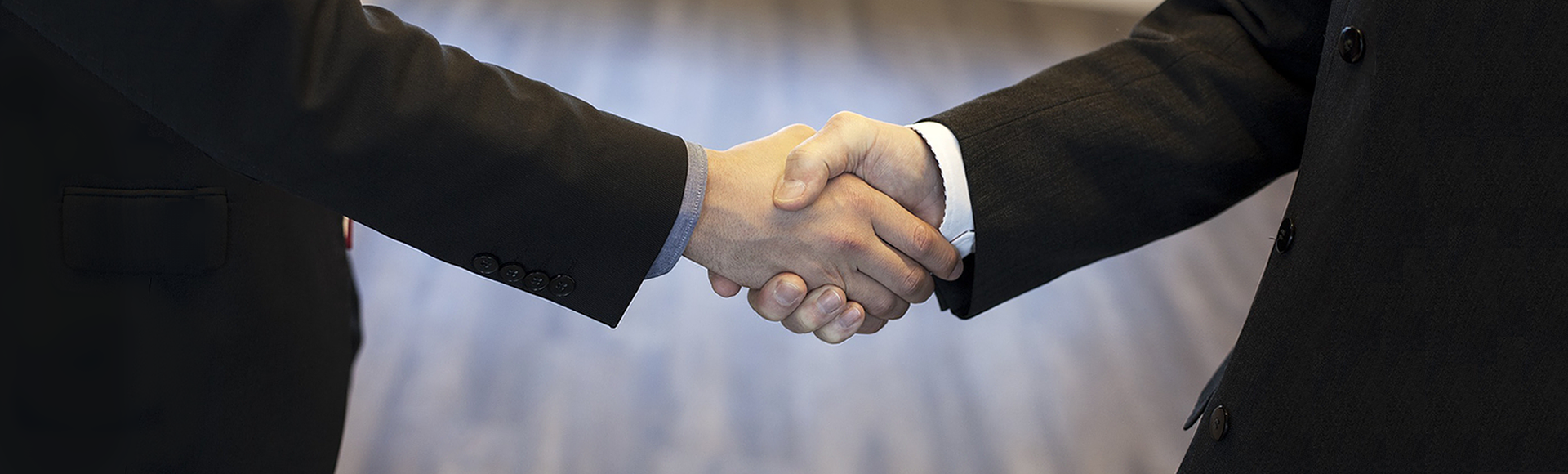 Contact 2Lift. Image of two arms (men) in business suits shaking hands.